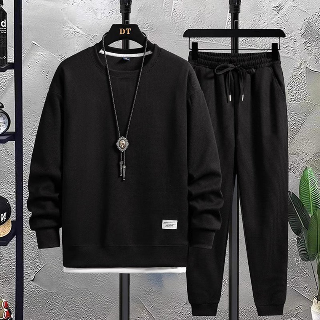 Zwart heren joggingpak, bestaande uit een sweatshirt en joggingbroek, ideaal voor casual en sportieve gelegenheden. Comfortabel en stijlvol ontwerp.