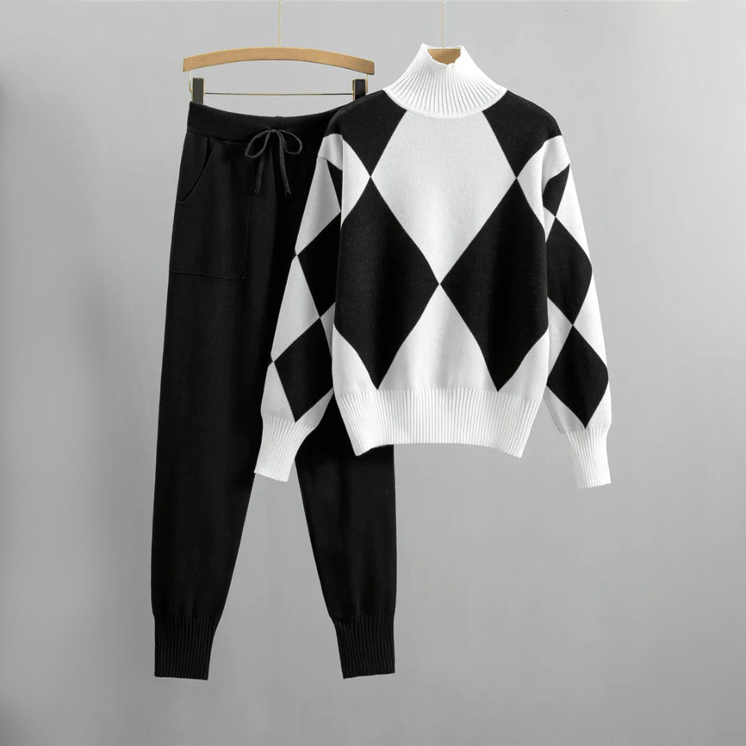 Zwart-witte damestrui met ruitpatroon en bijpassende zwarte broek, comfortabele winterset, warme kleding, modieuze damesoutfit.