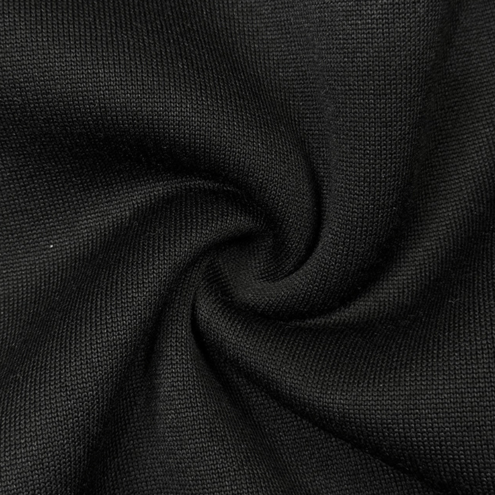 Zwarte katoenen stof close-up, gedraaid in een spiraalpatroon. Textielstructuur, duurzaam en ademend materiaal voor kleding en interieur.