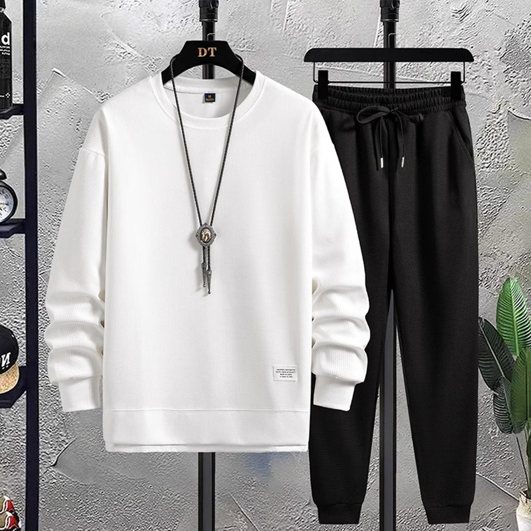 Wit heren joggingpak met lange mouwen en zwarte joggingbroek, casual sportkleding, comfortabele pasvorm, ideaal voor dagelijks gebruik.