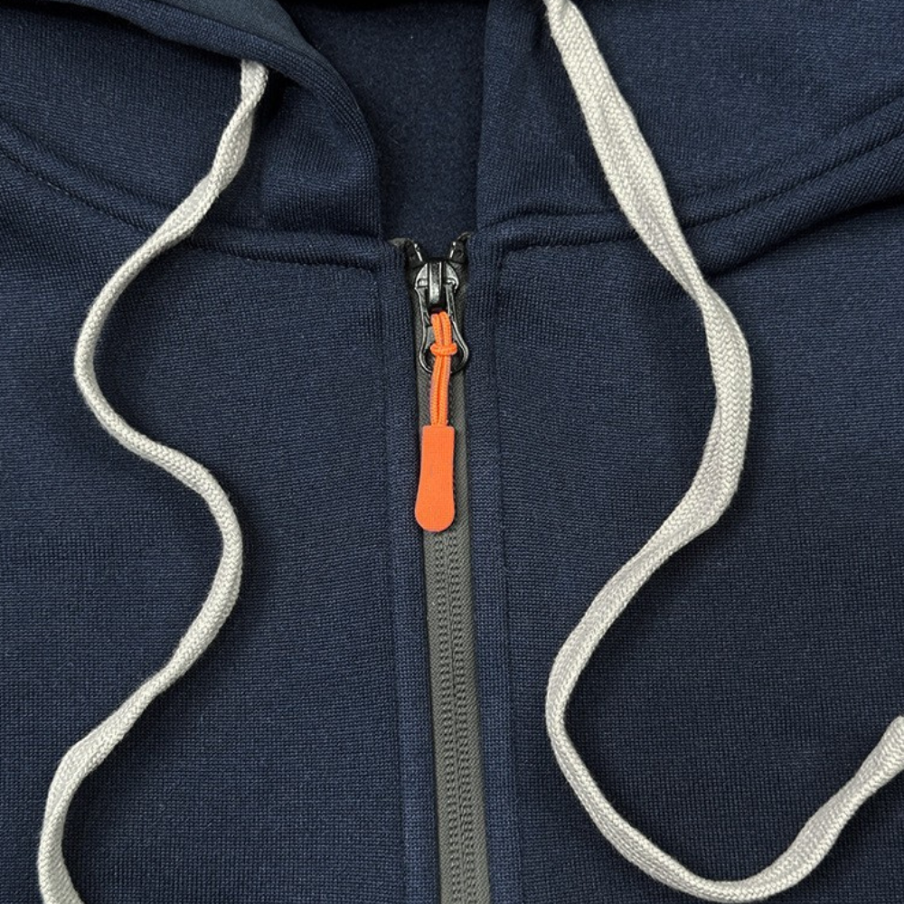 Donkerblauwe hoodie met grijze ritssluiting en witte trekkoorden, oranje ritstrekker. Comfortabele katoenen stof, casual kledingstijl.